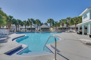 A swimming pool with lounge chairs and palm trees. - 1 Mi to Shore: Home w/ Patio in Panama City Beach (Panama City Beach)
