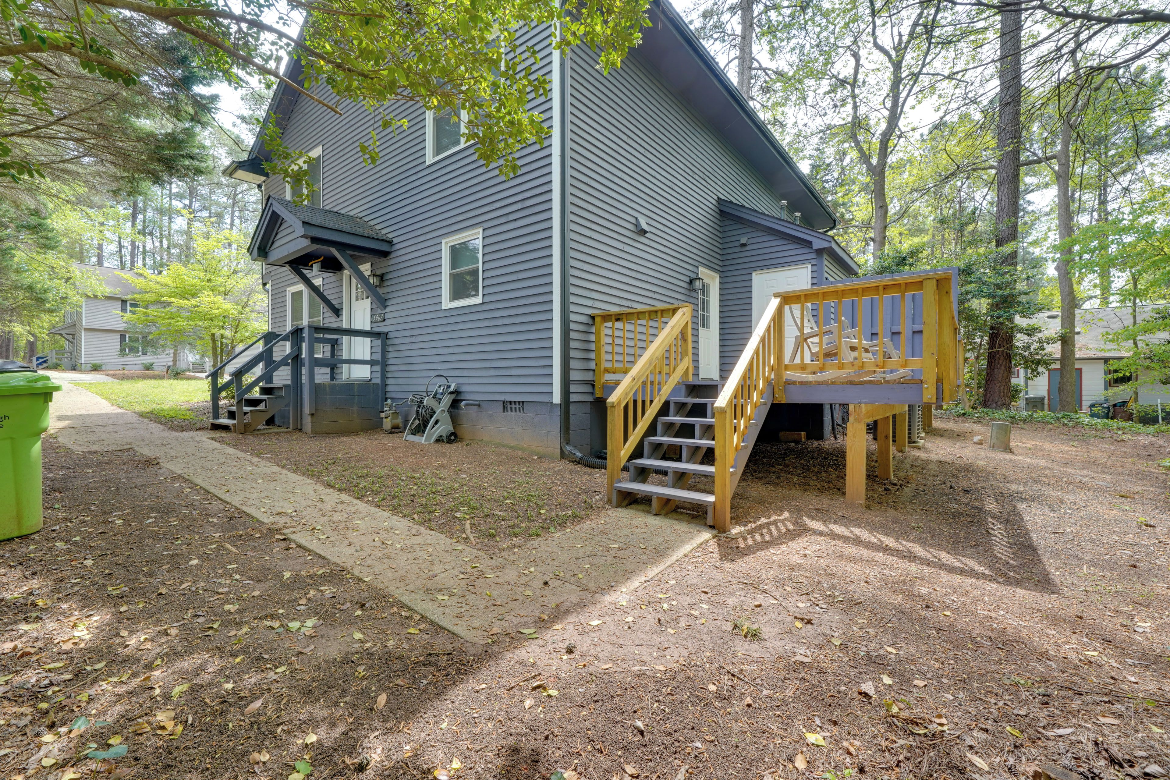 A two-story house with a wooden staircase and a porch.