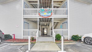 A two-story building with a balcony and a sign that reads "FineStre by the sea."