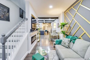 Un interno moderno con una scala, un divano, un'area pranzo e una cucina.