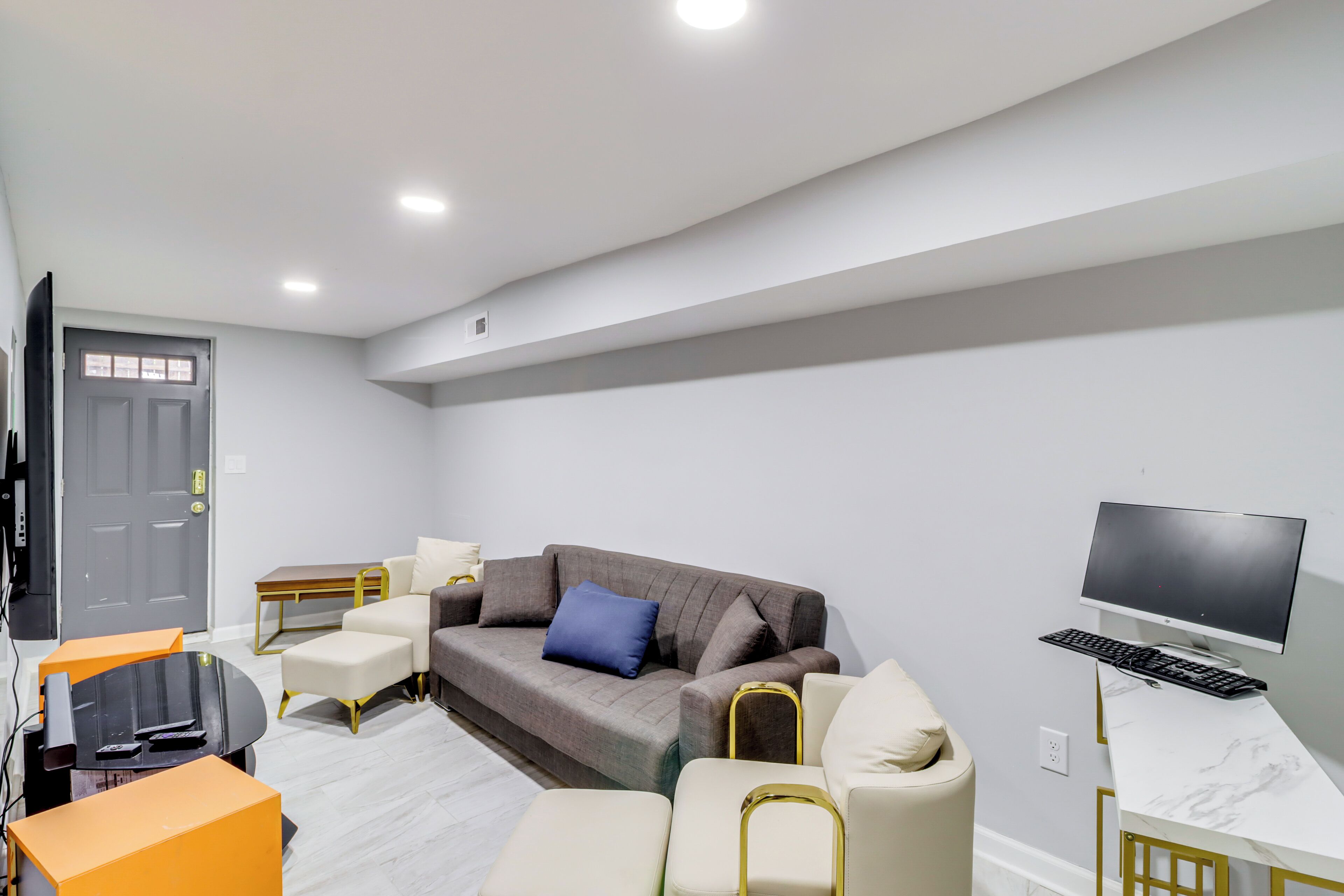 A modern living room with a grey sofa, a coffee table, and a TV.