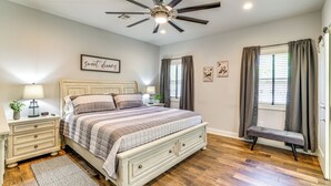 A bedroom with a bed, bedside tables, a ceiling fan, and a window with curtains. - < 1 Mi to Golf & Marina: Inviting Home in Afton! (Afton)