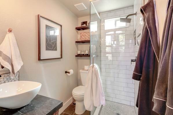 Un bagno con lavandino bianco, WC e cabina doccia in vetro.