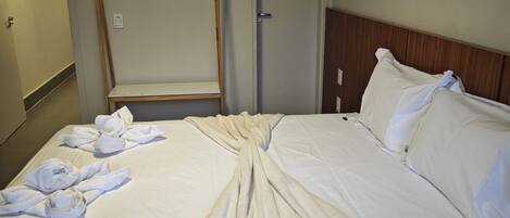 Una habitación de hotel con una cama grande, un cabecero de madera y un espejo en la pared.