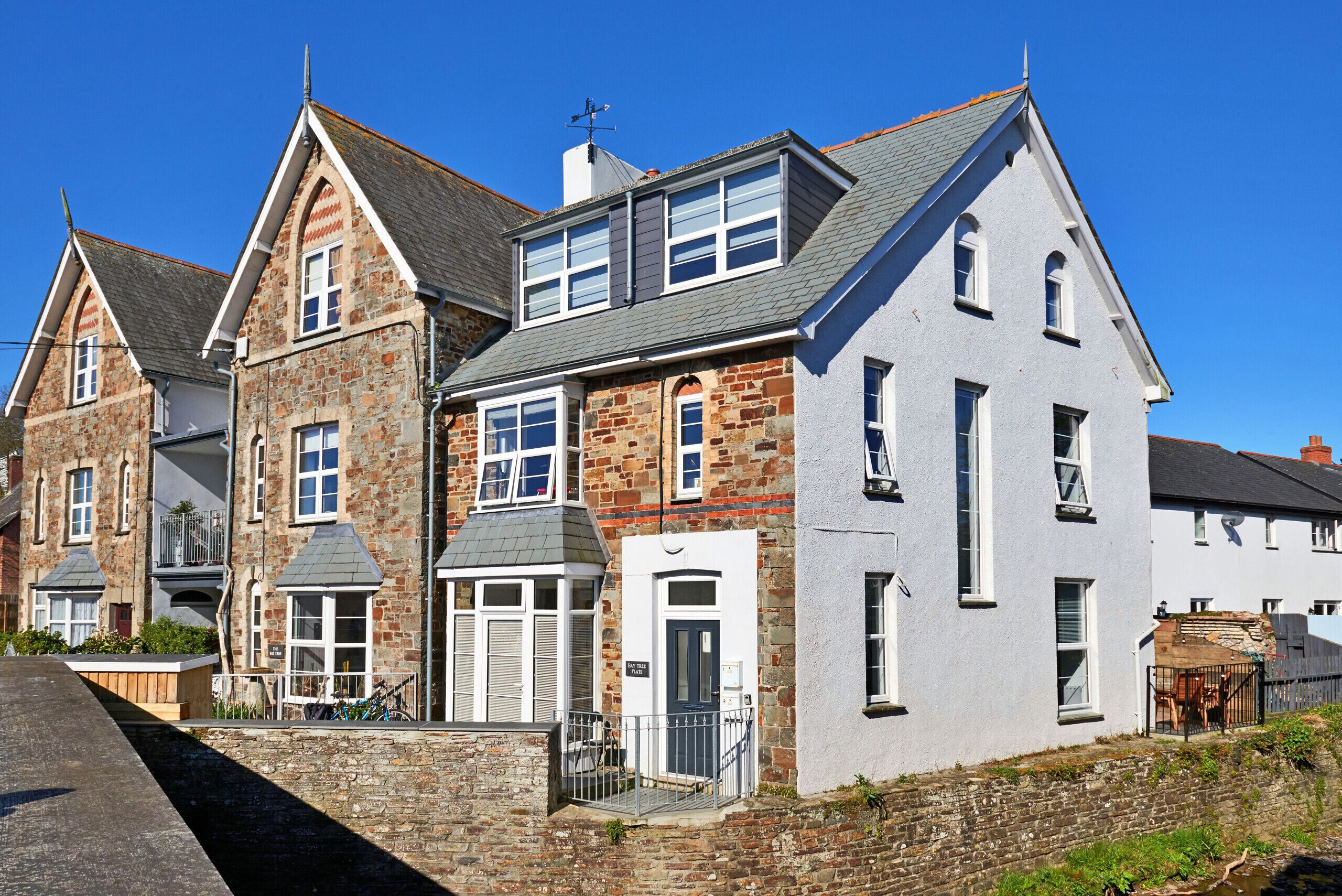 A row of traditional stone houses with gabled roofs and a central white building with a dark door.