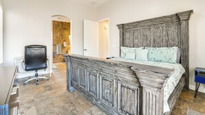 A bedroom with a large bed, a desk, and a chair. - Private Pool + Patio: Desert Abode in Goodyear (Goodyear)