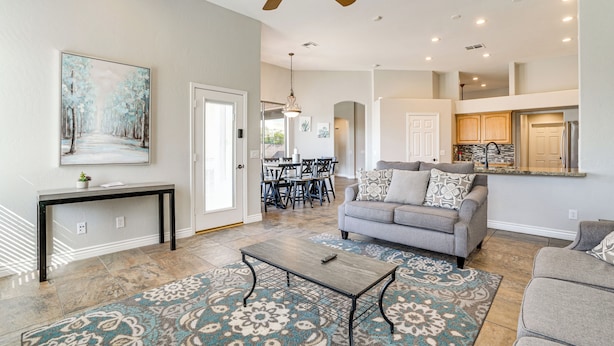 A spacious living room with a gray sofa, a coffee table, and a patterned rug. - Private Pool + Patio: Desert Abode in Goodyear (Goodyear)