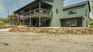 Une maison à deux étages avec des fondations en pierre, un balcon et un garage.