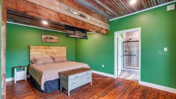A bedroom with a wooden headboard, a bed with a quilt, a nightstand, a dresser, and a walk-in closet.