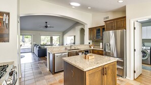 A modern kitchen with granite countertops, stainless steel appliances, and wooden cabinets. - Newly Renovated Home w/ Pool Access in Tucson! (Saddlebrooke)