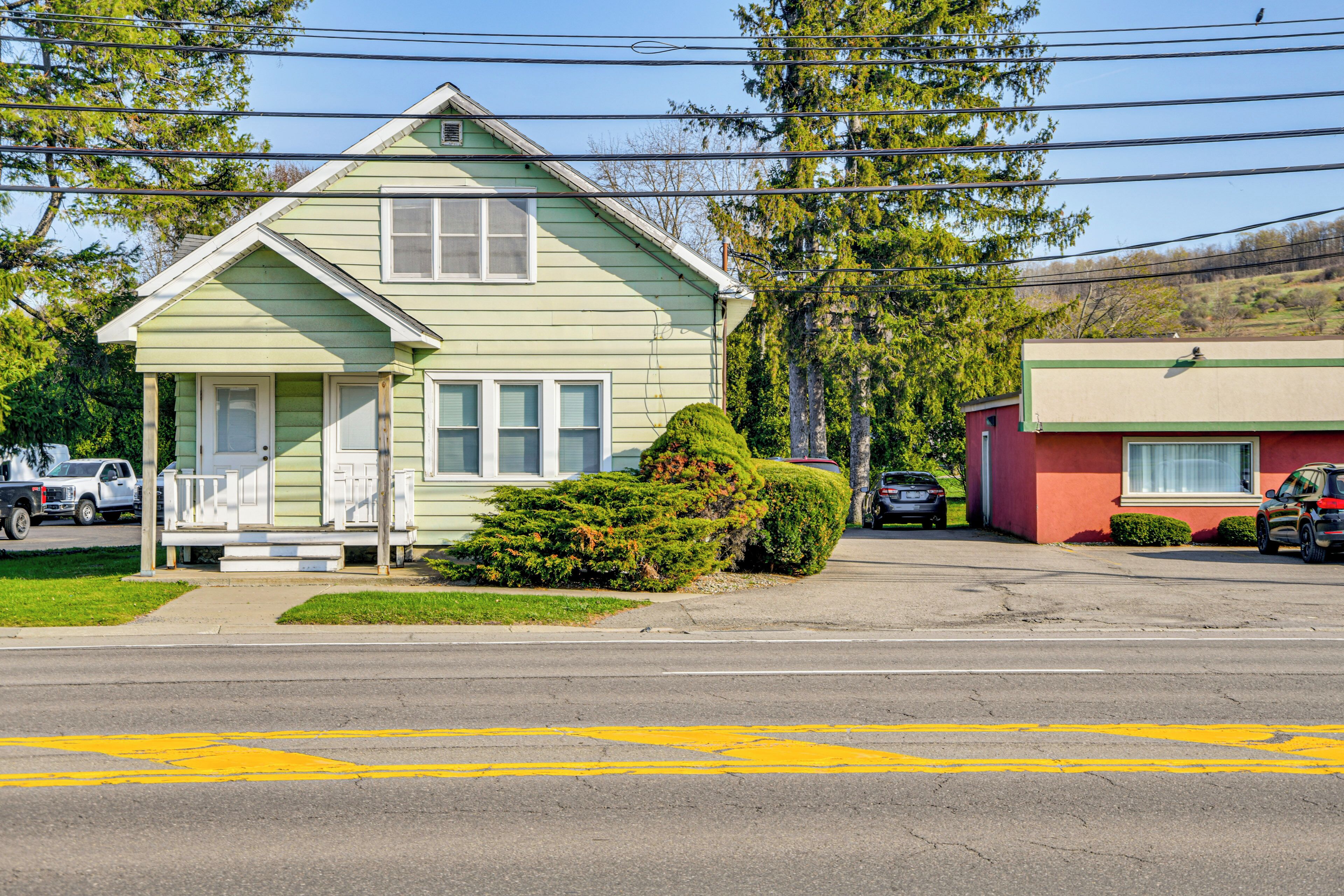 A two-story house with a porch and a small front yard.
