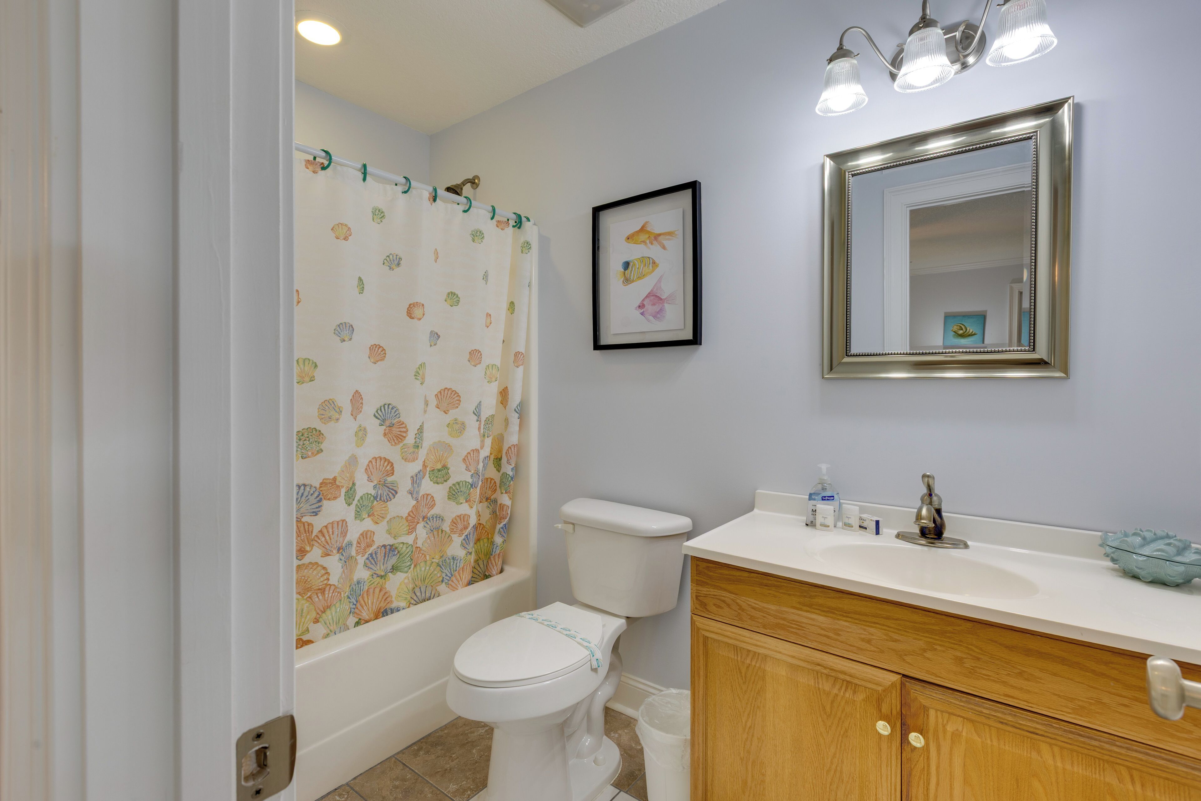 A bathroom with a toilet, a bathtub, a sink, and a mirror.