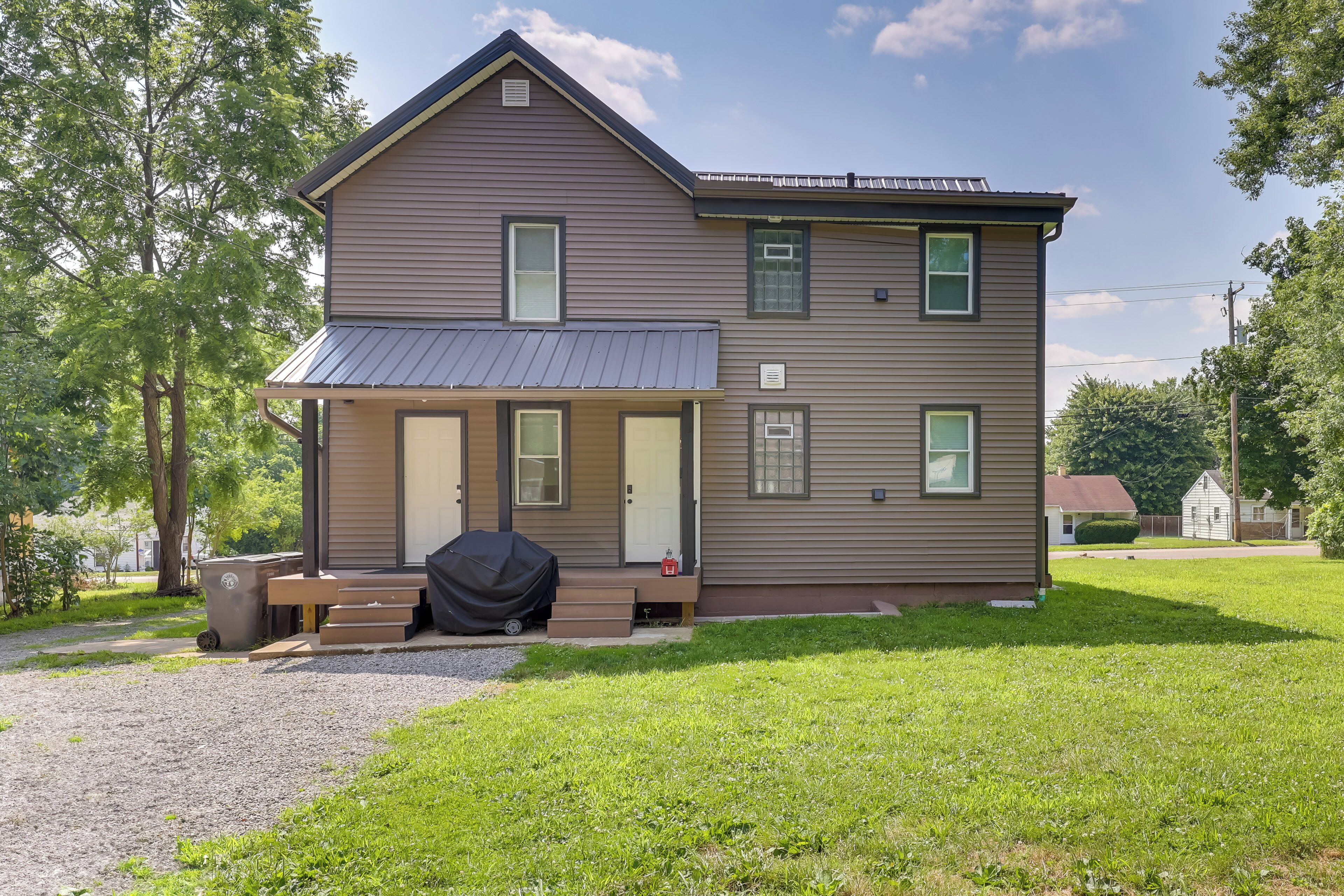 A two-story house with a covered porch, a garage, and a well-maintained lawn.