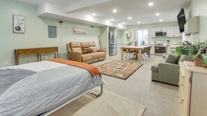 Amplia sala de estar con una cama grande, dos sofás, una mesa de comedor y una cocina al fondo.