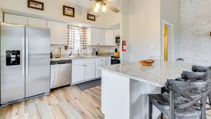A modern kitchen with white cabinets, stainless steel appliances, a granite countertop, and a ceiling fan. - Beach Access: Bbq-ready Poconos Family Getaway! (Blakeslee)