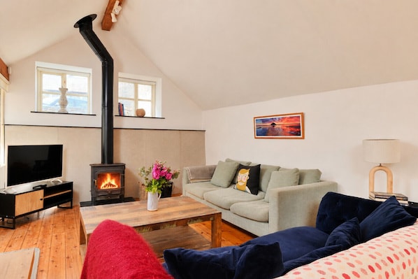 A cozy living room with a fireplace, a television, a sofa, and a coffee table.
