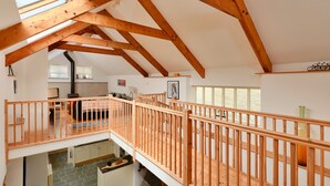 Un loft amplio con vigas de madera a la vista, un balcón y vista al interior.