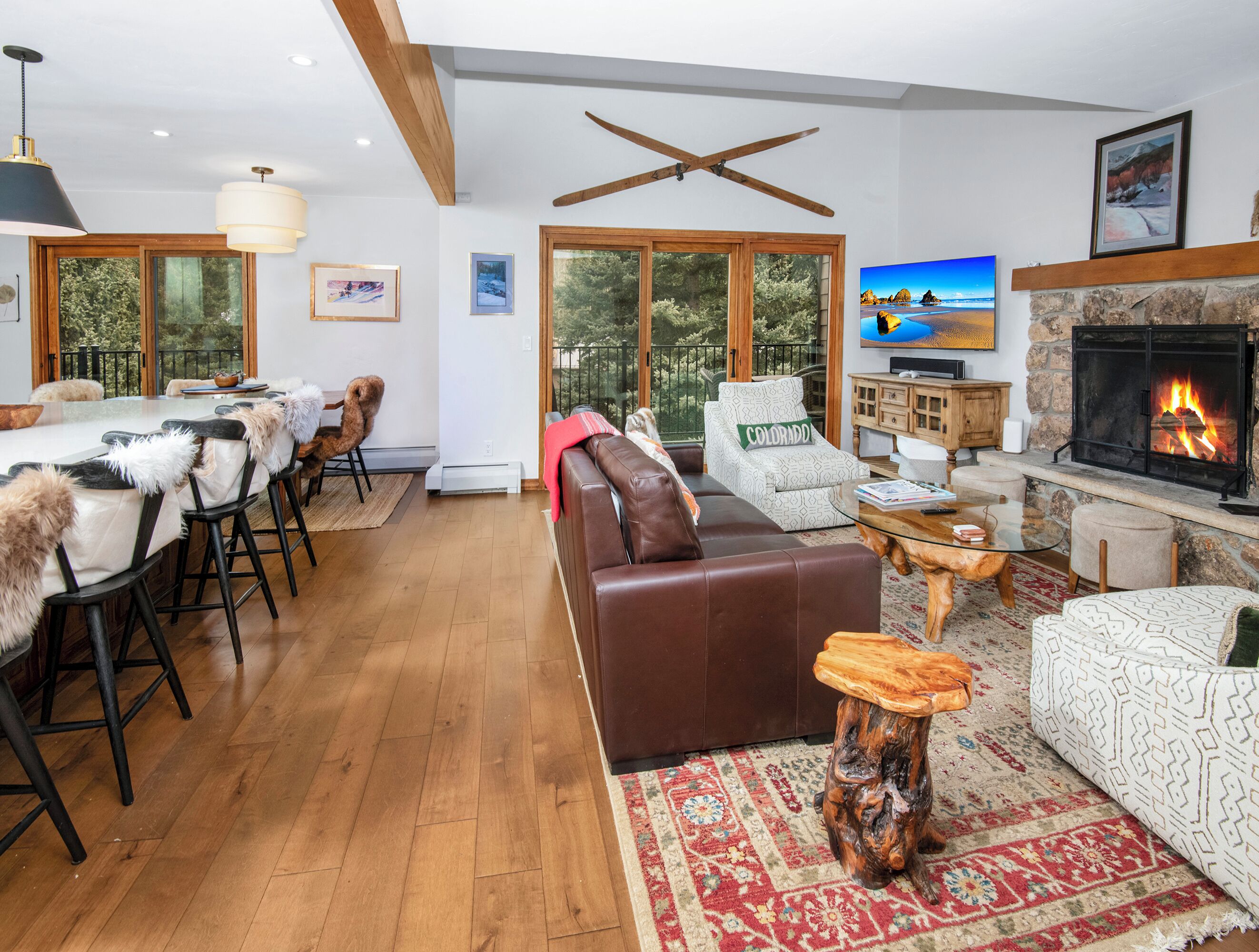 A spacious living room with a fireplace, a dining area with a large table and chairs, and a cozy seating area with a sofa and armchairs.