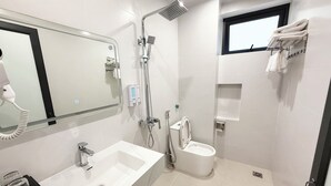 A modern bathroom with a large mirror, a sink, a toilet, and a shower. - Gia Bao Hotel Phu Tho (Van Phu)