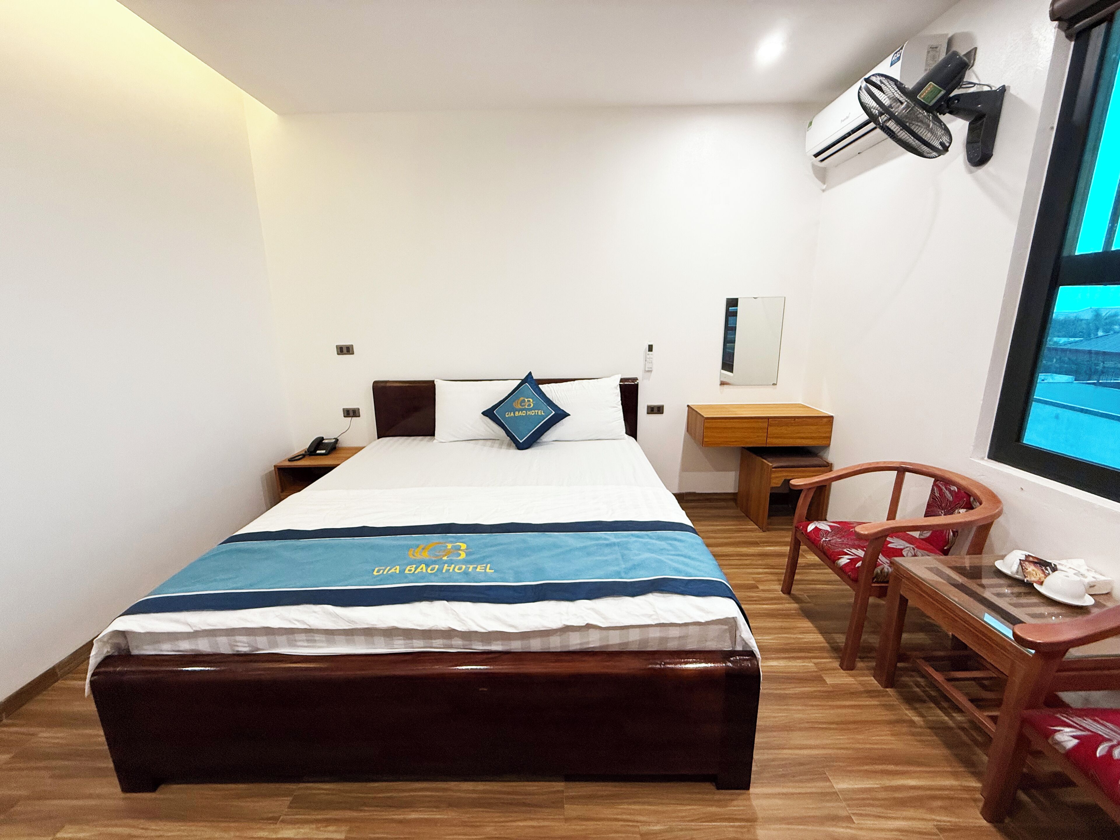 Une chambre d’hôtel avec un lit, une table de chevet, une chaise et une fenêtre donnant sur un paysage agréable.