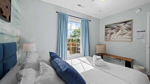 A bedroom with a bed, a bedside table, a lamp, a bench, a window with curtains, and a painting on the wall. - 3BR Condo Near Ark Encounter, 8 Guests, Parking (Williamstown)
