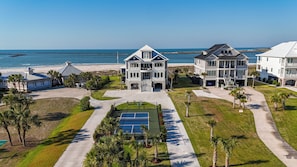 A beachfront property with multiple houses, a tennis court, and a view of the ocean. - Freedom  Point: Oceanfront Luxury w/Pool, Game Room, Sauna & Cold Plung (Garden City Beach)