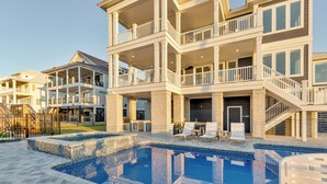 A multi-story residential building with a swimming pool, outdoor seating, and a gated entrance. - Freedom  Point: Oceanfront Luxury w/Pool, Game Room, Sauna & Cold Plung (Garden City Beach)