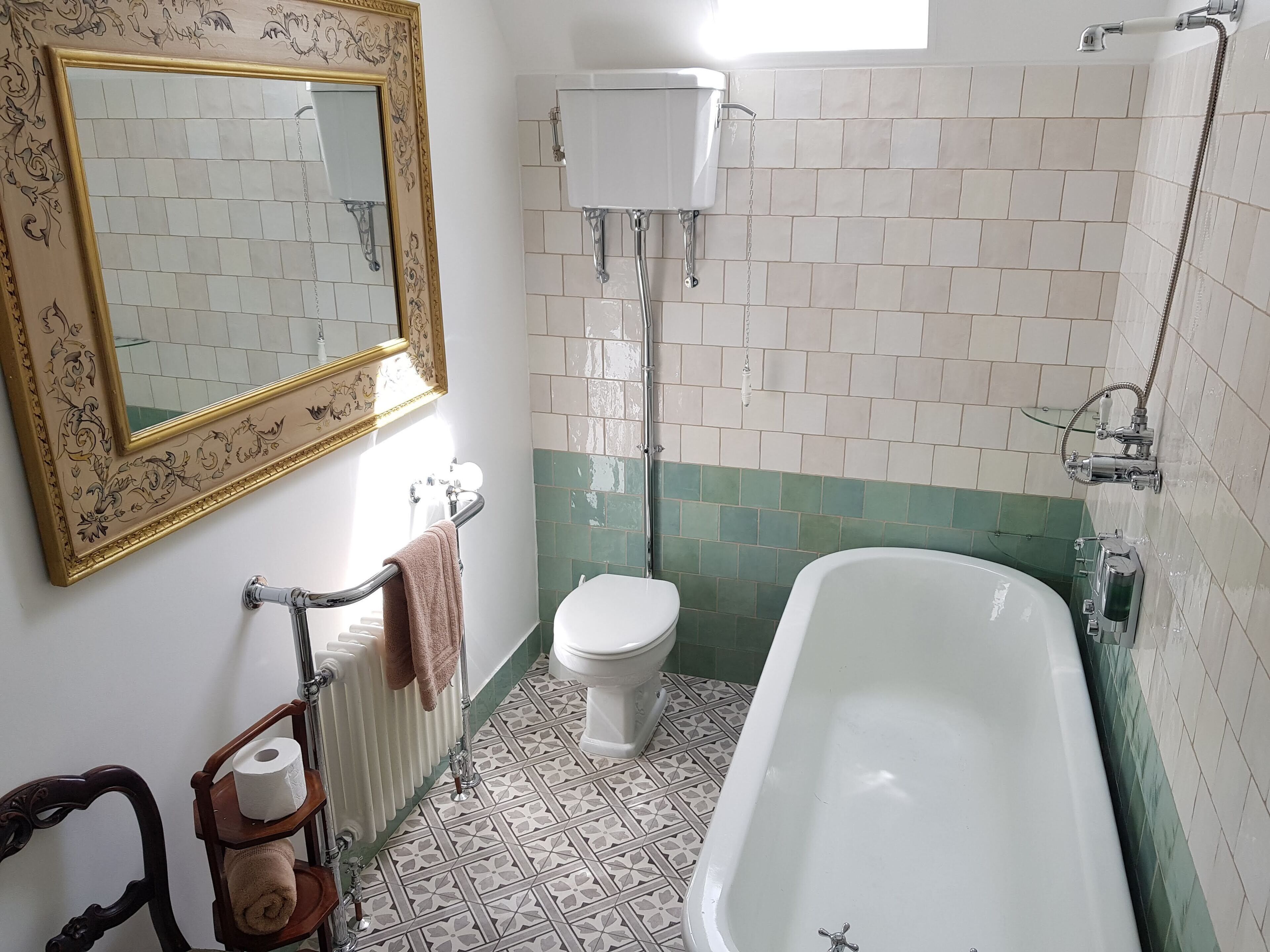 Un baño con bañera, inodoro y radiador.
