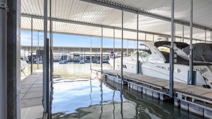 A covered marina with boats docked, a clear view of the water, and a covered walkway. - Immaculate Lands End #735 3Bed/2Bath New Remodel! (Osage Beach)