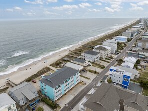 Una zona residencial costera con propiedades frente a la playa, una carretera y una playa.