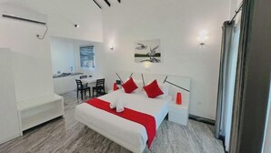 Een moderne hotelkamer met een bed, nachtkastje en een klein bureau.