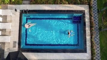 Relax by the pool surrounded by lush greenery and a beautifully landscaped outdoor space.