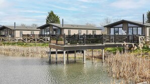 Una propiedad frente al lago con cabañas modernas, un muelle y una zona verde.