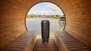 A sauna with a wooden interior and a view of a lake.