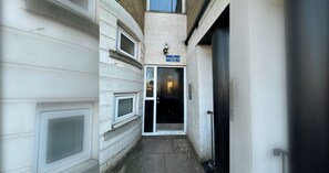 A narrow alleyway with a door marked '40' and a sign for 'Bacon Street E2' indicating the address.