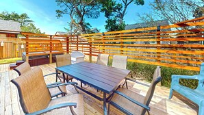 Eine Terrasse im Freien mit Tisch und Stühlen, umgeben von einem Holzzaun.