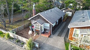 A single-story house with a front porch, a garage, and a small attached shed. - Sandpiper Cottage at Seaside Beach (Seaside)