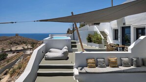 A modern outdoor terrace with a hot tub, seating area, and a view of the sea. - Amphora Meltemi Seaview Gem w/ Private Jacuzzi (Akrotiri)