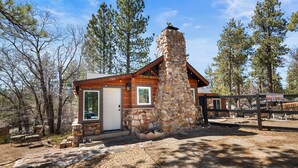 A stone building with a chimney, a door, and a window. - StoneHauz Cabin built in 1926 (Big Bear Lake)