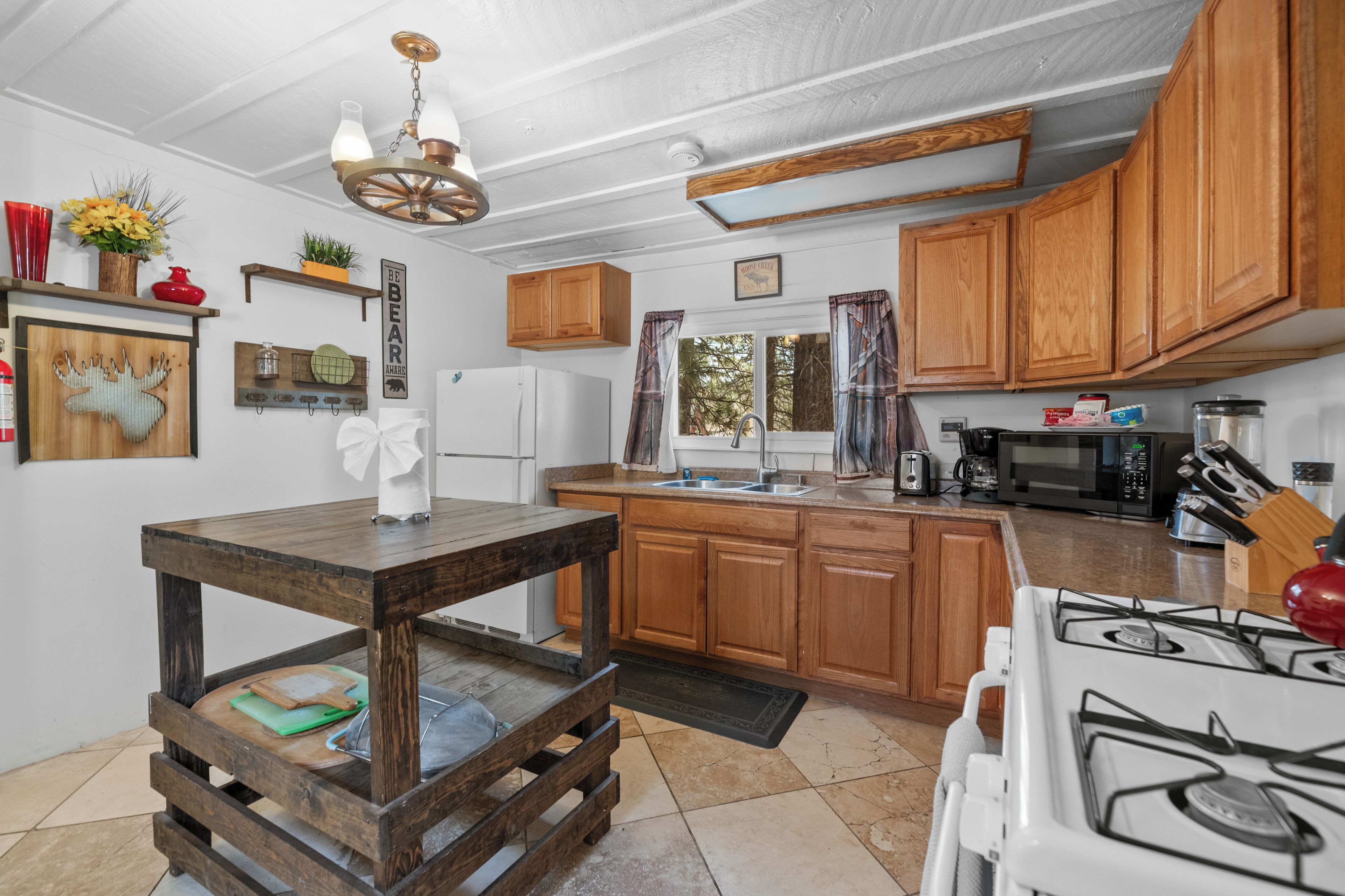 A kitchen with wooden cabinets, a white stove, and a wooden table.
