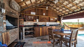Une cuisine rustique avec un four en briques, des armoires en bois et un mur recouvert de carreaux.