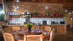 A kitchen with a brick wall, wooden cabinets, and a tiled backsplash.
