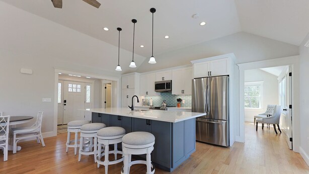 A modern kitchen with a central island, stainless steel appliances, and a dining area with white chairs. - Life of Reilly - Private & Serene Rockport Escape (Rockport)