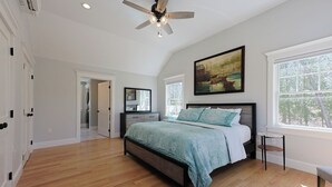 A spacious bedroom with a large bed, a ceiling fan, and a painting above the bed. - Life of Reilly - Private & Serene Rockport Escape (Rockport)