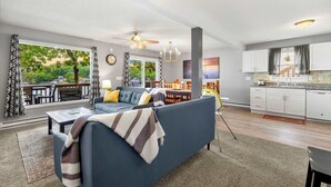 A modern living room with a sofa, coffee table, and a view of the outdoors. - Dockside Dream w/ Kayak & Dock (Rocky Mount)