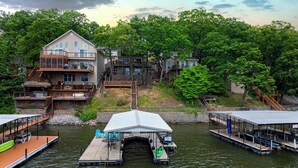 A waterfront property with a multi-level house, dock, and boat launch area. - Dockside Dream w/ Kayak & Dock (Rocky Mount)