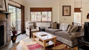 Una sala de estar con sofá, sillones, una mesa de centro y una chimenea.