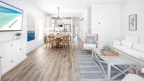 A spacious living area with a wooden floor, a dining table with chairs, a white sofa, and a coffee table. - Private Pool-Steps to Sugar Sand and Sunset Views (Destin)