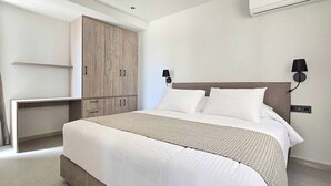 A modern bedroom with a large bed, a wardrobe, and a desk. - Villa Trapezia Pearl (Kolympia)