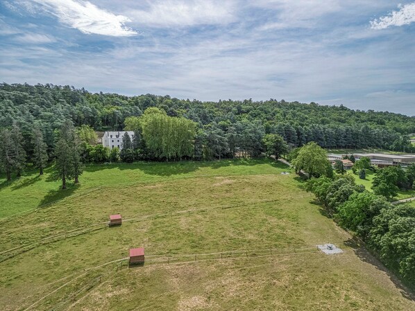 A large open field with a few buildings and trees. - Château de la Roche (Vourles)